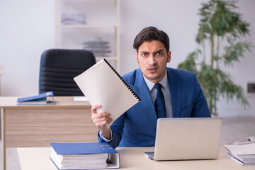 Young male employee sitting in the office