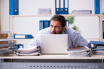 Young male employee unhappy with excessive work in the office