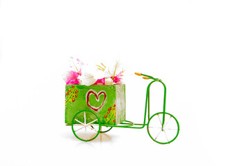 Obraz premium A hand-painted distressed-looking rustic tricycle with flowers painted on the sides and with pretty pink flowers in the box. A heart on the side of the box illustrates a personalized romantic message.