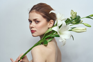 Beautiful woman naked shoulders bouquet flowers cosmetics clean skin
