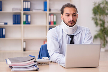 Fototapeta premium Young neck injured male employee working in the office