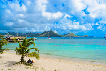 Naklejka premium Tropical Beaches and beautiful waves crashing into picture-perfect rocks covered in the embrace of lively moss. Beach swarming with Jetskis and boat/ Cactus overlooking the sea. 