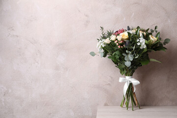 Beautiful bouquet with roses on white wooden table. Space for text