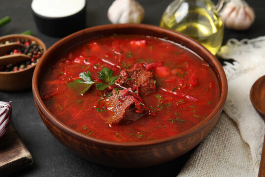 Stylish brown clay bowl with Ukrainian borsch served on black table