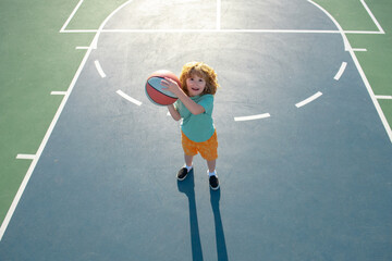 Cute litle child boy training basketball. Kids basketball school.