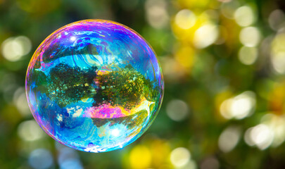 A large soap bubble flies in the park.