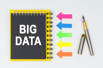 On a white background lies a pen, arrows and a notebook with the inscription - BIG DATA