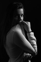 Obraz premium Black and white portrait of a young brunette woman in a studio on a black background