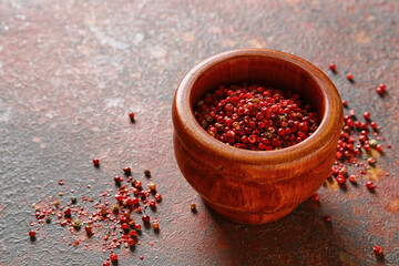 Bowl with red peppercorns on grunge background