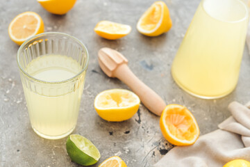 Fresh lemons and glass of juice on grunge background