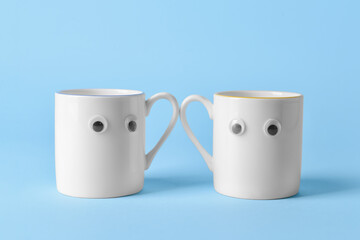 Funny cups on color background