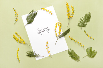 Beautiful mimosa flowers and paper sheet with word SPRING on color background