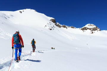 Rope team mountaineering with crampons on glacier Sexegertenferner towards Sexegertenspitze and...