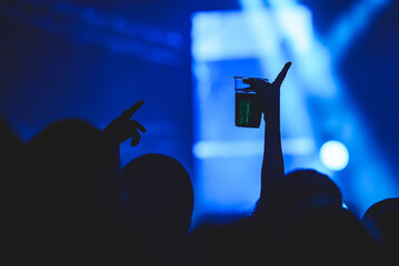 Human hand holding alcohol on the concert