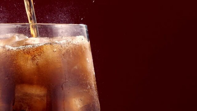 Slow Motion Of Pouring Cola Drink With Ice Cubes Inside close-up 300 fps