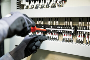 Electricians work to connect electric wires in the system, switchboard, electrical system in...