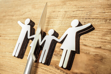 knife divides the whole family. divorce idea. wooden figure. wood background.
