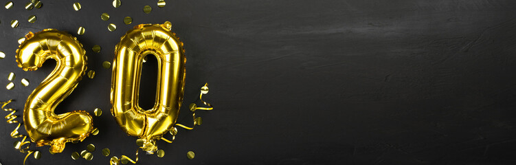 gold foil balloon number twenty. Birthday or anniversary greeting card with inscription 20. Black concrete background. Anniversary celebration. Banner. - obrazy, fototapety, plakaty