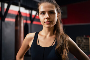 Portrait of beautiful athletic woman with perfect muscular body looks at camera in the gym centre....