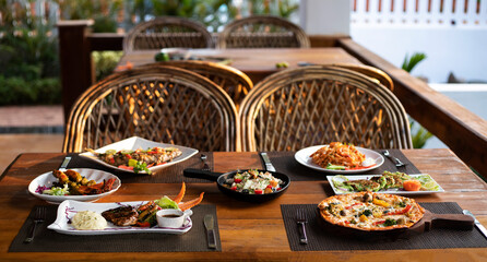 wooden table with variety of food outdoors 