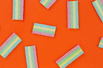 Colorful gummy candy pattern on an orange background. Soft gums look from above. Variation concept. Gay colors. Sweet food dessert.