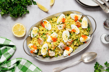 Traditional british cuisine. Fresh prepared kedgeree with smoked haddock and boiled egg. Served with fresh parsley and red caviar. top view