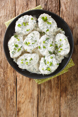 Montenegrin cuisine Kuvana Krtola boiled potatoes with curd yoghurt sauce close-up in a bowl on the table. vertical top view from above