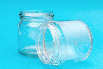 Two empty glass jars on blue background. - 425209255
