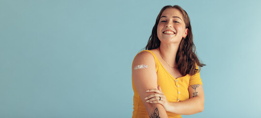 Beautiful woman looking happy after getting vaccine - obrazy, fototapety, plakaty