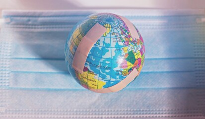 Globe with plasters on a face mask . Concept of Corona Virus in the world