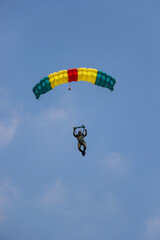 Skydiver On Colorful Parachute in blue sky