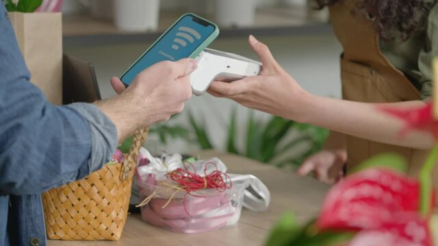 The customer pays for the purchase using NFC technology using a phone, contactless payment .Flower shop.