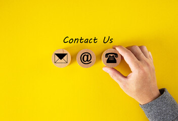Contact Us, Customer support concept. Wooden cubes with mail, phone and email icons on table,...