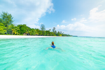 Fototapeta na wymiar Woman swimming in caribbean sea turquoise transparent water. Tropical beach in the Kei Islands Moluccas, summer tourist destination in Indonesia.