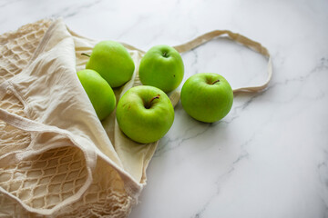 Zero waste shopping concept. Fresh vegetables in eco cotton bags on table in the kitchen. Zero waste shopping and sustainable lifestyle concept. Slow life.