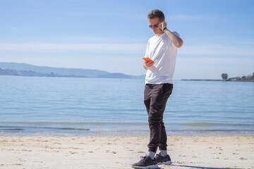 young man on the beach using mobile phone