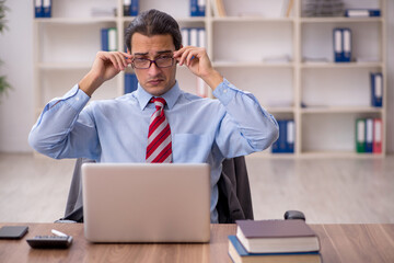 Fototapeta premium Young male employee sitting at workplace