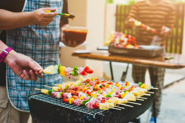 The chef is roasting a barbecue at an outdoor party at home.