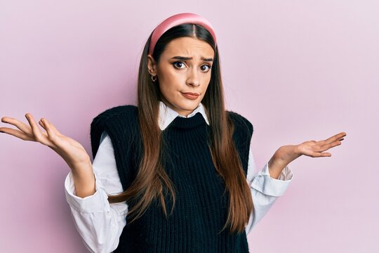 Beautiful brunette young woman wearing casual clothes clueless and confused with open arms, no idea and doubtful face.