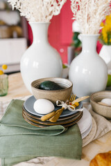 A beautiful table setting with crockery for the celebration of Easter. Egg on a plate