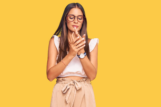 Young hispanic woman wearing casual clothes and glasses suffering pain on hands and fingers, arthritis inflammation