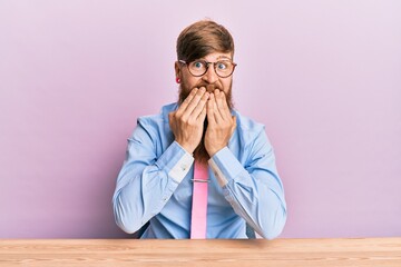 Young irish redhead man wearing business shirt and tie sitting on the table laughing and...