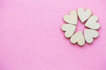 Valentine's day background. row of wooden hearts on a pink background. Valentine's day concept. Top view, place for an inscription, advertising