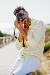 Fototapeta premium Handsome man photographing in a coastal area.
