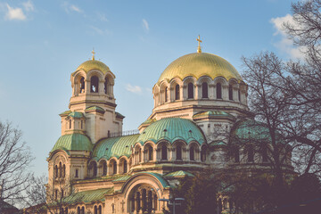 Fototapeta premium Alexander Nevsky cathedral Sofia, Bulgaria. Bulgarian Orthodox cathedral in the capital of Bulgaria. Built in Neo-Byzantine style. Photo taken in a sunset light with trees around