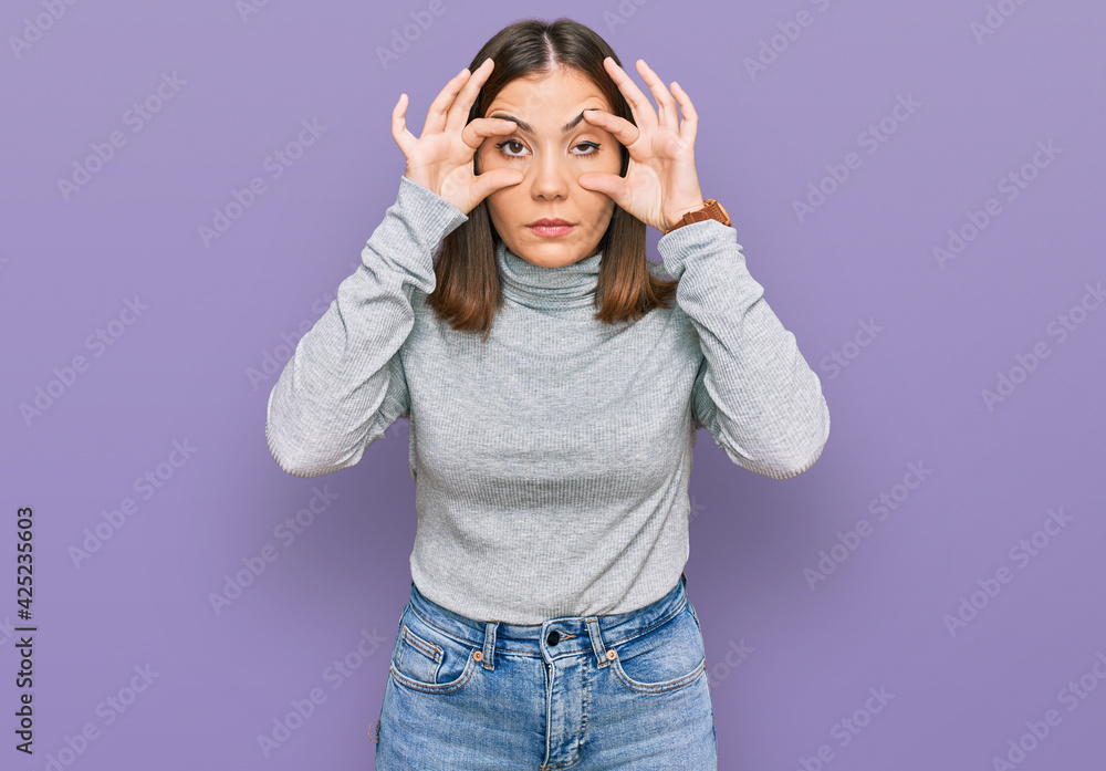 Poster Young beautiful woman wearing casual turtleneck sweater trying to open eyes with fingers, sleepy and tired for morning fatigue