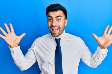 Young hispanic man wearing business clothes celebrating crazy and amazed for success with arms raised and open eyes screaming excited. winner concept