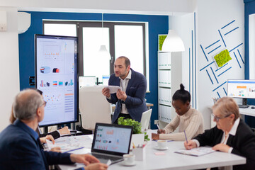 Young business owner in conference room screaming at multiethnic coworkers due to financial project failure. Reprimanding unsuccessful results and rivalry concept.