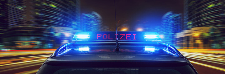Polizei Auto mit Blaulicht bei Nacht in einer Stadt
