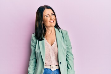 Middle age brunette woman wearing casual clothes winking looking at the camera with sexy expression, cheerful and happy face.